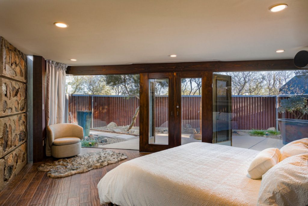 Expansive master bedroom with glass wall to bring the outdoors in.