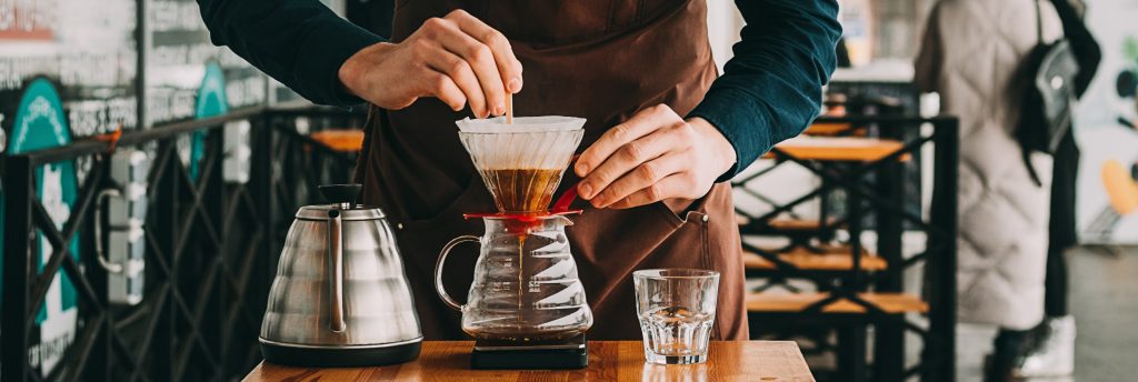 Man making coffee in a stainless steel French press