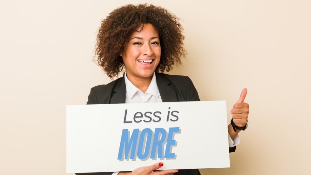 Woman giving thumbs up, holding a sign that says "Less is More."